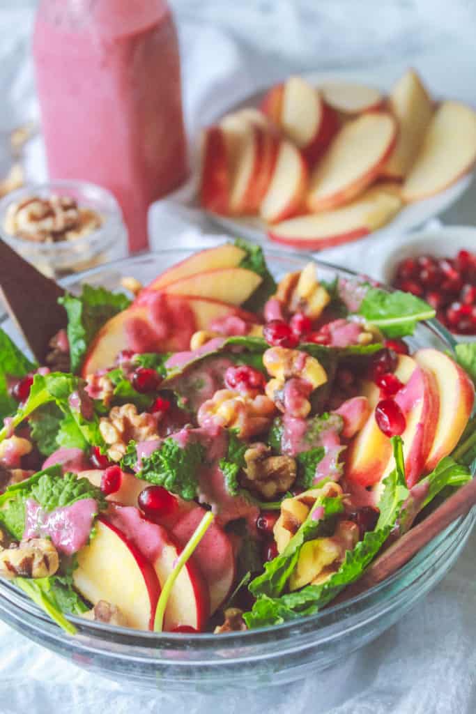 Healthy and refreshing winter salad with kale, pomegranates, walnuts, and apples that makes a perfect side for stews, soups, casseroles, and more!