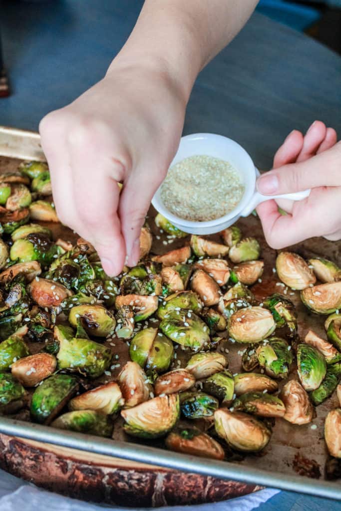 Looking for an easy side dish recipe? Make this asian-style Sesame Roasted Brussel Sprouts that are crispy and baked to perfection! #vegan #brusselsprouts #veganrecipe #sidedish