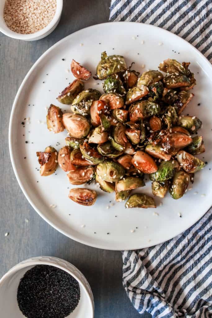 Looking for an easy side dish recipe? Make this asian-style Sesame Roasted Brussel Sprouts that are crispy and baked to perfection! #vegan #brusselsprouts #veganrecipe #sidedish
