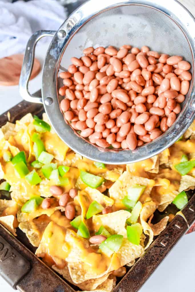 Vegan loaded nachos recipe with tomatillos and vegan queso cheese sauce. It’s easy to make and makes a perfect appetizer or a meal! #nutfree #nachos #veganrecipe