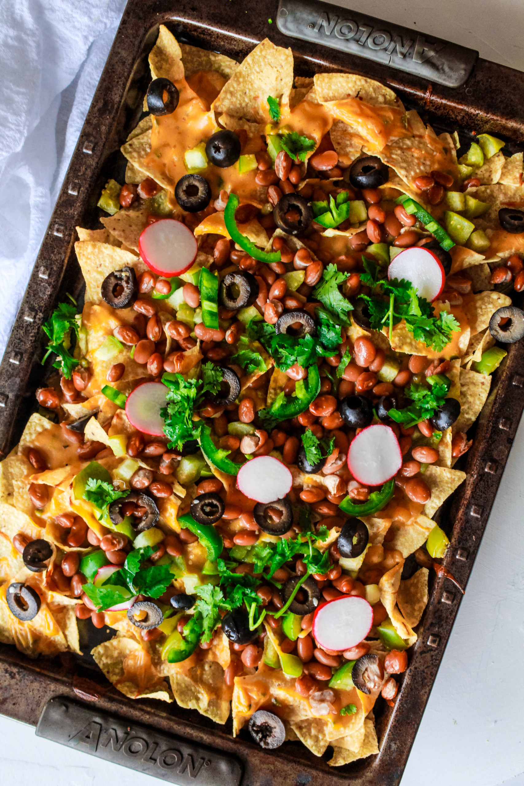 Vegan loaded nachos recipe with tomatillos and vegan queso cheese sauce. It’s easy to make and makes a perfect appetizer or a meal! #nutfree #nachos #veganrecipe