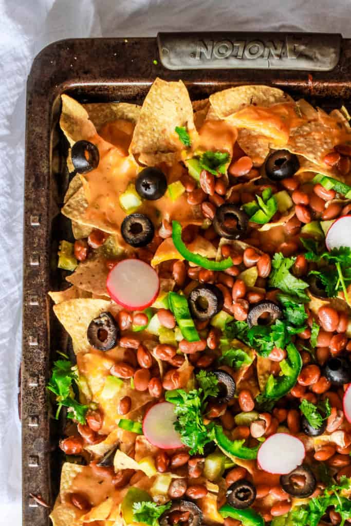 Vegan loaded nachos recipe with tomatillos and vegan queso cheese sauce. It’s easy to make and makes a perfect appetizer or a meal! #nutfree #nachos #veganrecipe