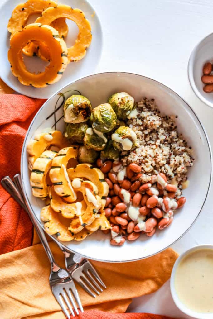 This healthy, plant-based bowl is perfect as an autumn lunch or dinner. It’s high in protein and comes with a delicious, creamy maple sauce! #fallrecipe #grainbowl #delicata