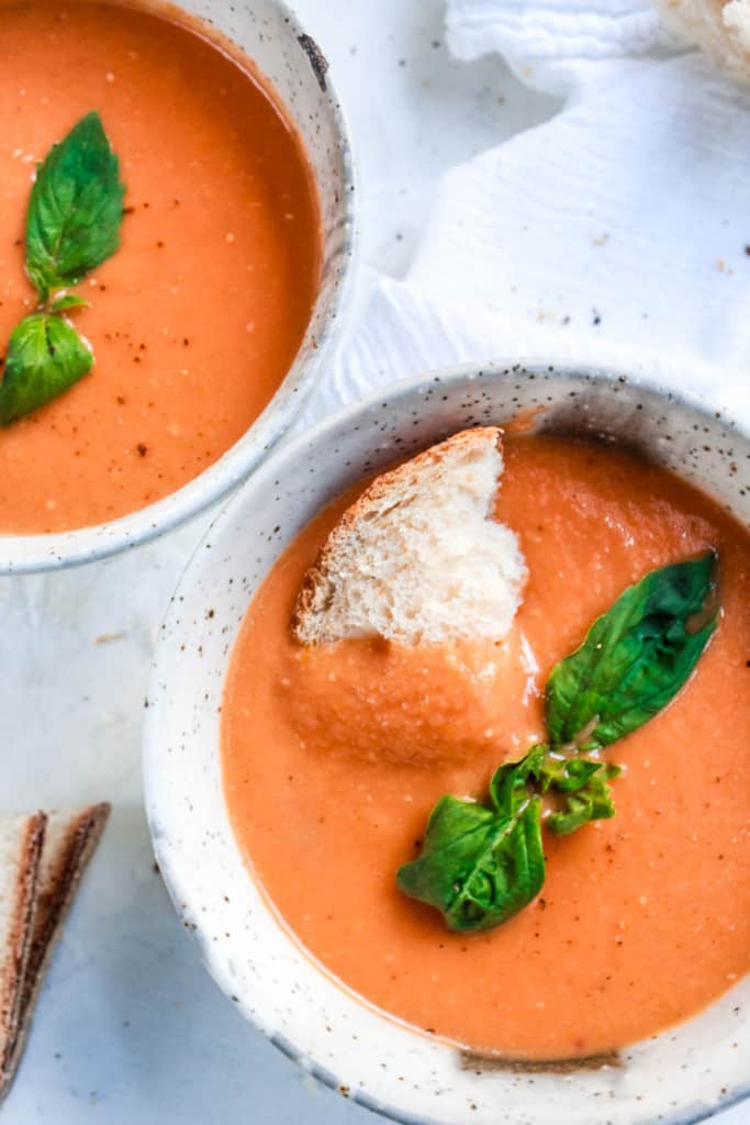 Easy, homemade, creamy tomato soup made with real tomatoes and basil. It’s 100% vegan, healthy, and cooks in 30 minutes! #tomatosoup #vegansoup #veganrecipe