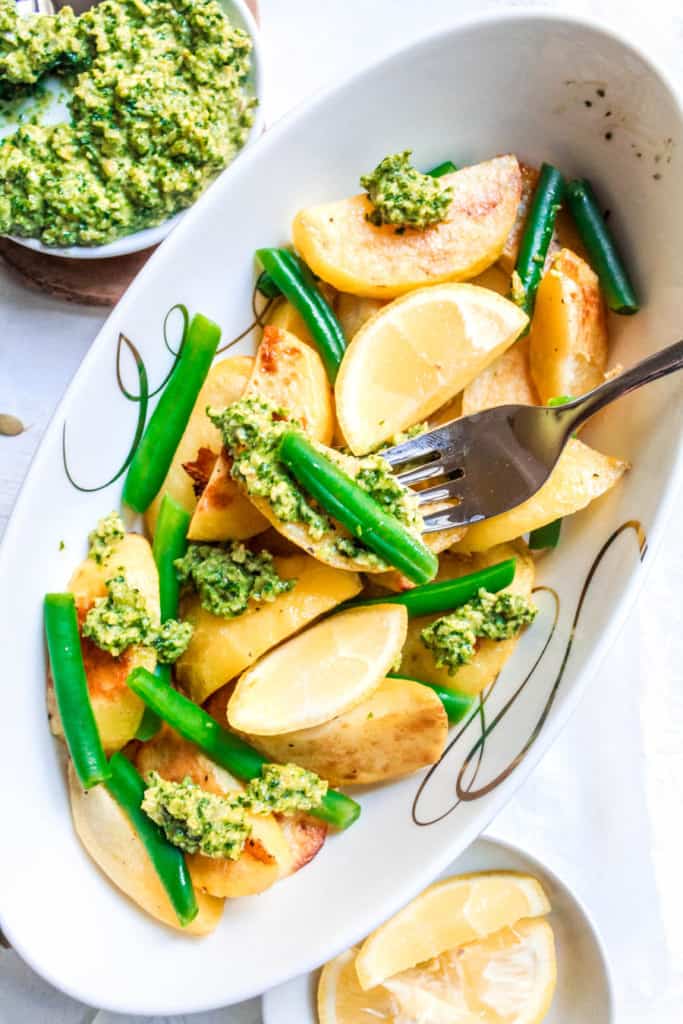 Oven roasted, easy, yellow potatoes with green beans is a healthy side dish for any meal! Cilantro Pesto adds a touch of herb freshness and ties the dish together. #potatoes #roastedpotatoes #sidedish